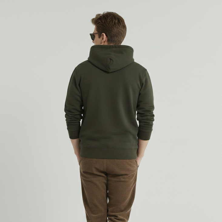 Man wearing a green hoodie and brown pants on a light gray background
