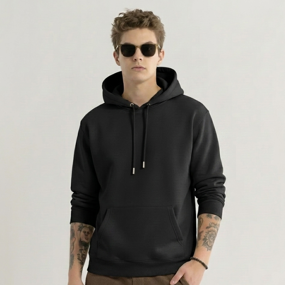 Man wearing a black hoodie and sunglasses on a plain background