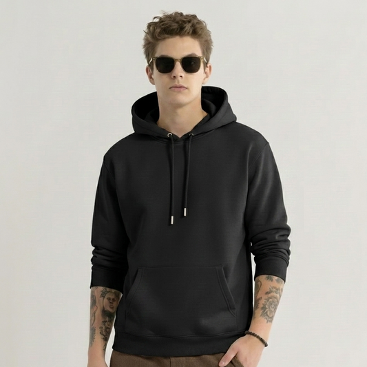 Man wearing a black hoodie and sunglasses on a plain background