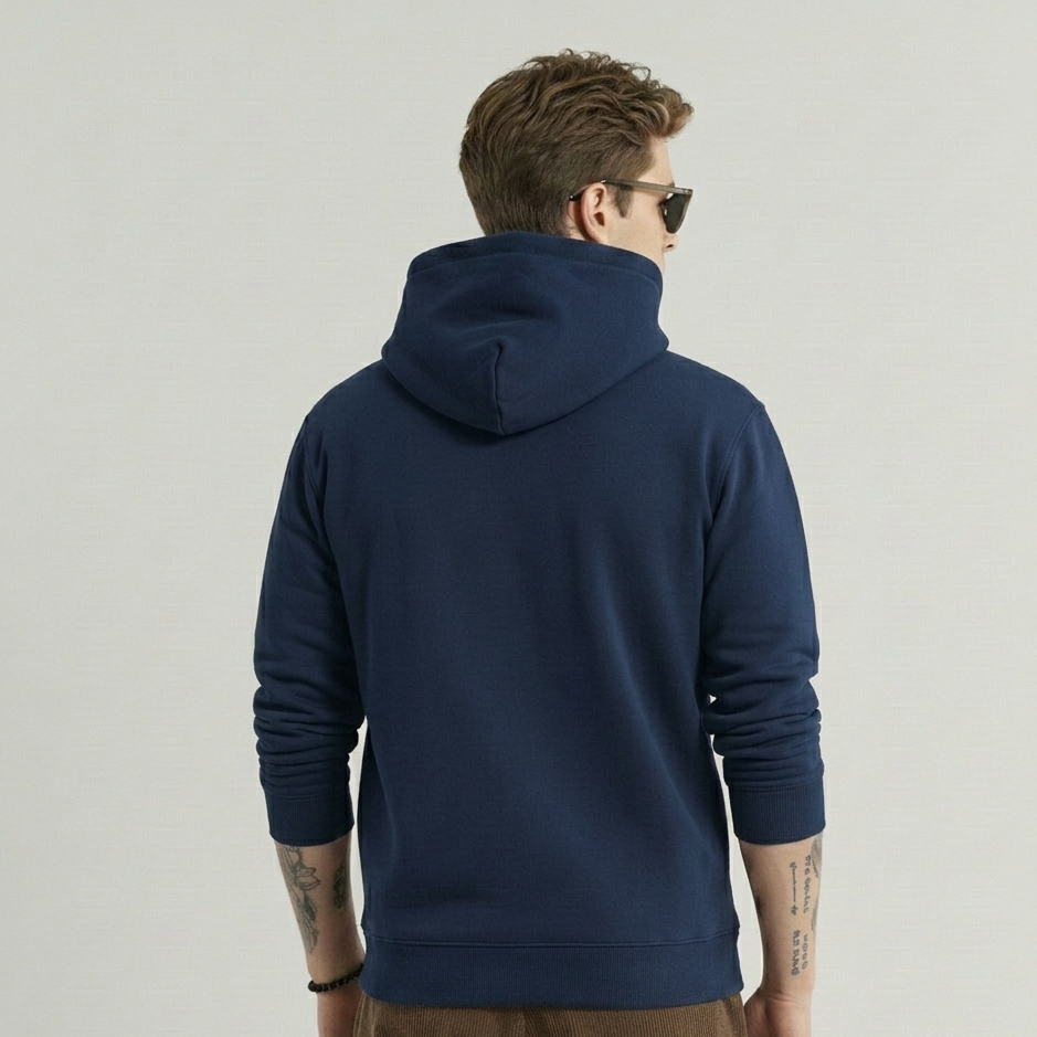 Man wearing a navy blue hoodie from behind on a light gray background
